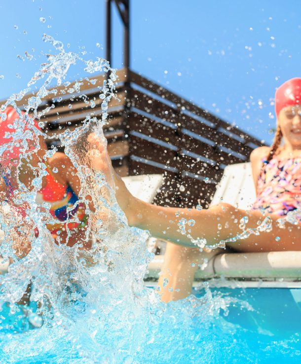 The portrait of happy smiling beautiful teen girls at the swimming pool. Little child at blue wate. Pool, leisure, swimming, summer, recreation, healthy lifstyle concept